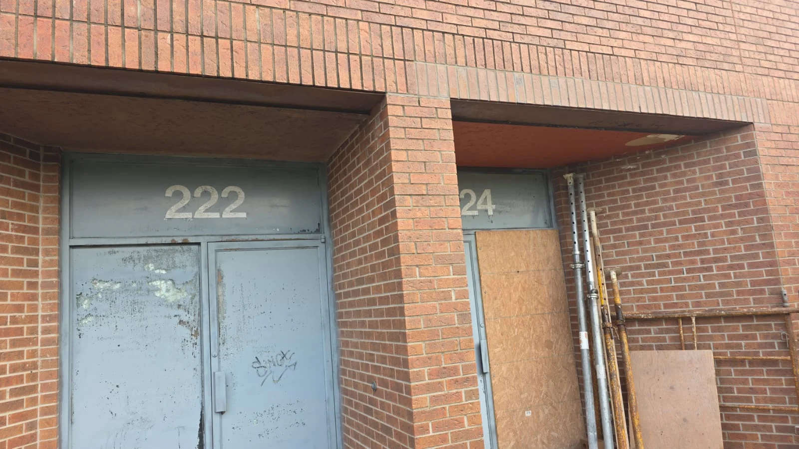 Wide site view of two recessed commercial entrances in a brick facade