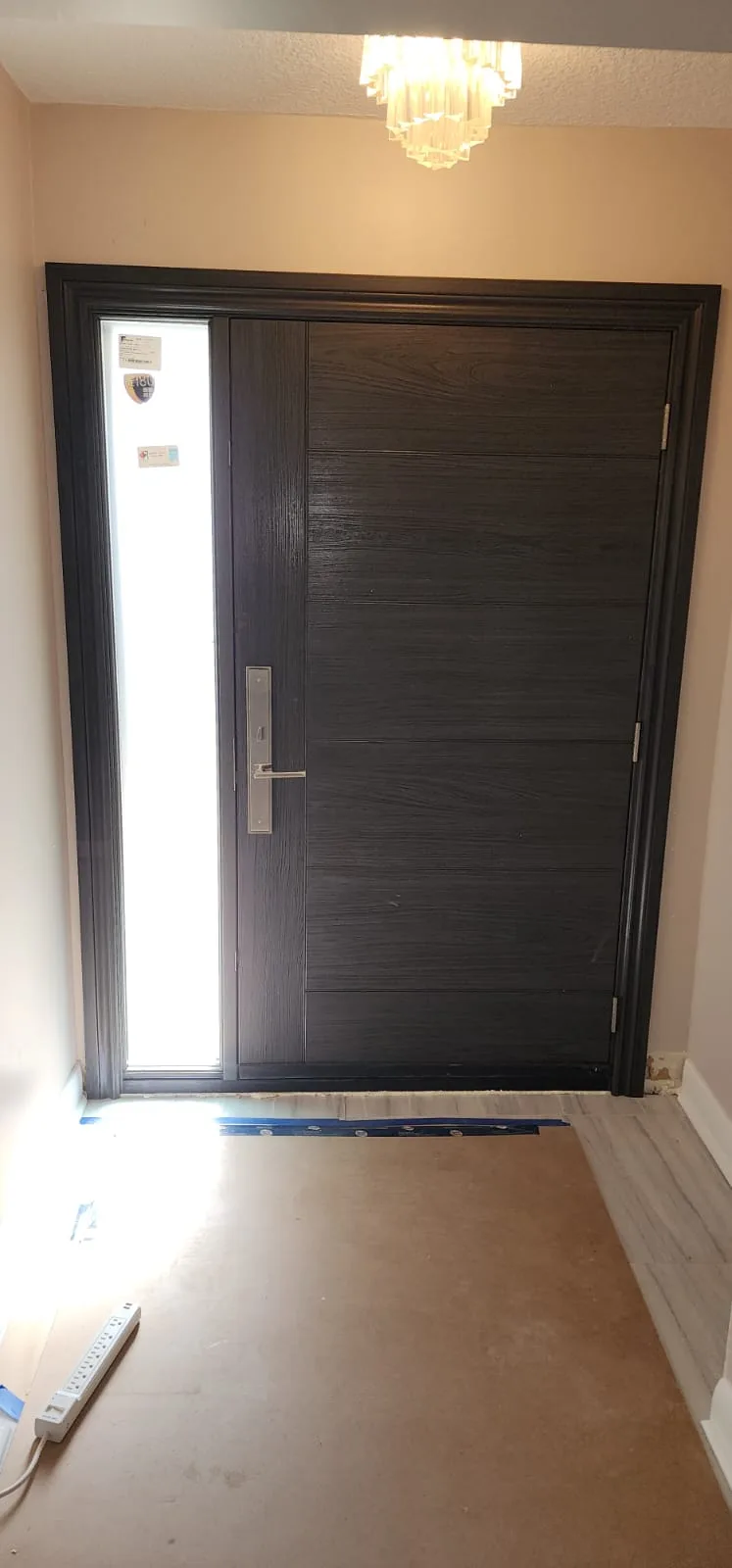 The new dark front door and its sidelite seen from inside the hallway