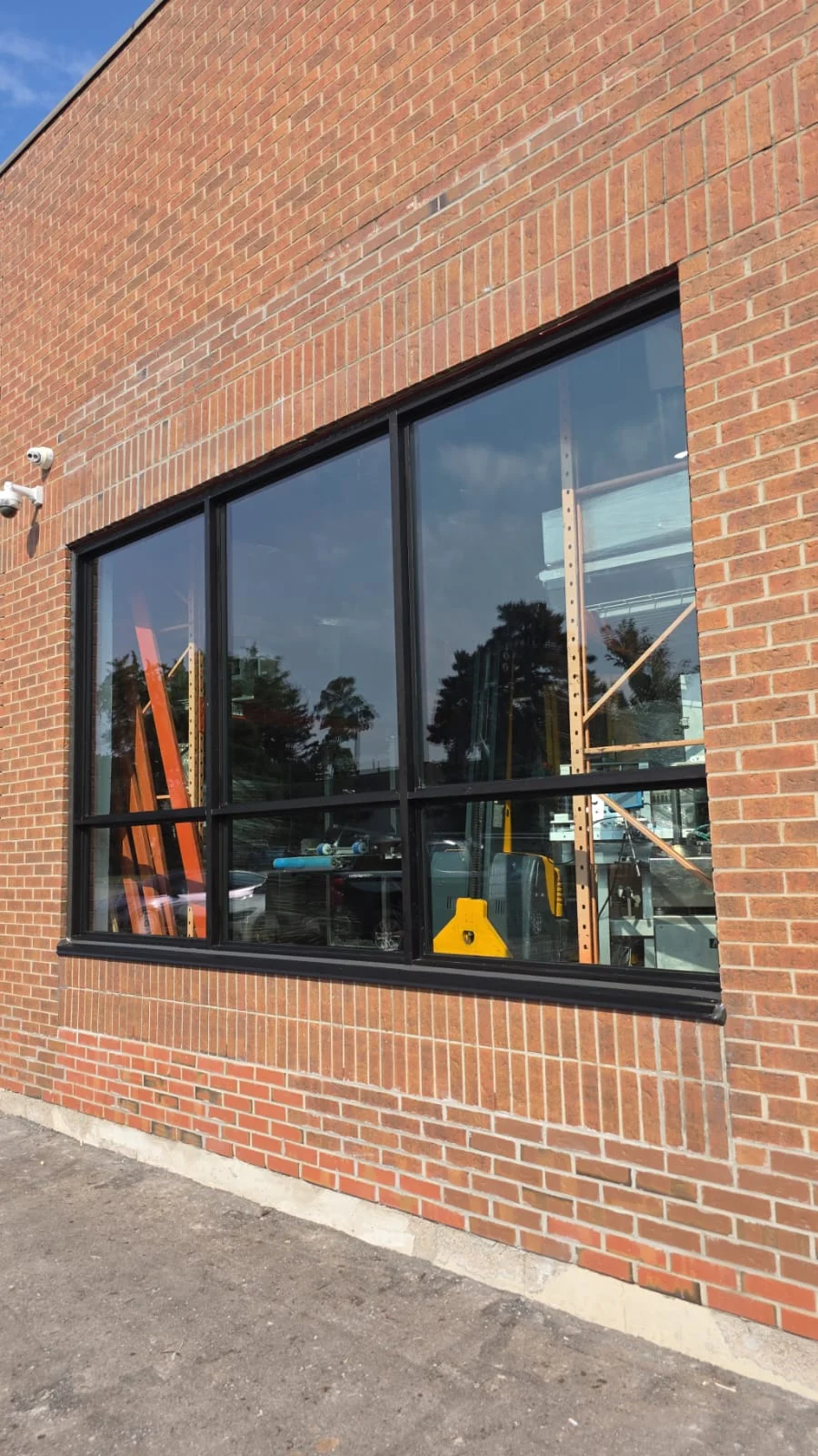 Dark-framed storefront glazing set into a red-brick commercial facade